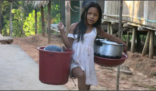 APRENDER HACIENDO. Niña matsés regresa a su casa, después de ayudar a su familia, ocupándose de lavar platos y olla en el río. [imagen 1]
